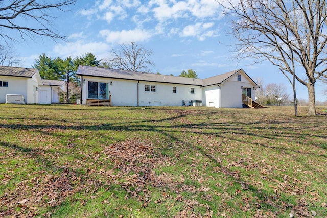 back of house featuring a yard and stucco siding