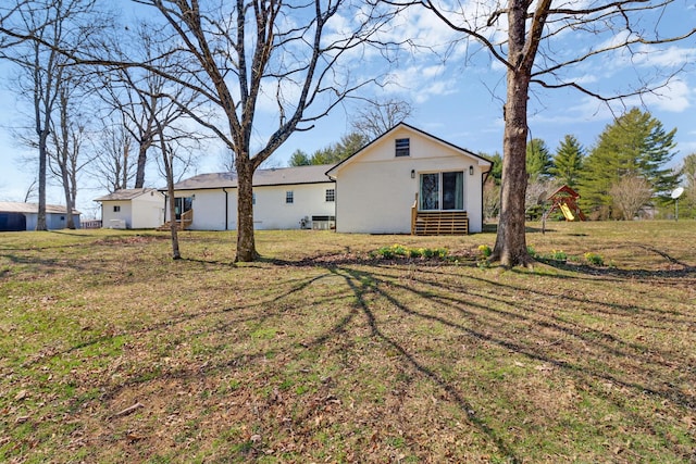 exterior space with stucco siding and a yard