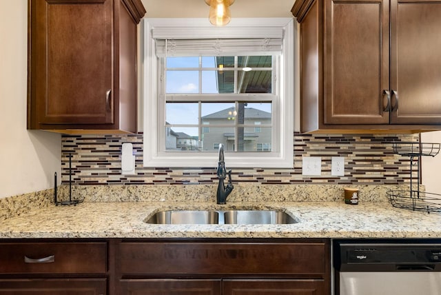 1561 Kestrel Dr, Clarksville, TN 37040 - kitchen with light stone counters, a sink, dark brown cabinetry, dishwasher, and tasteful backsplash