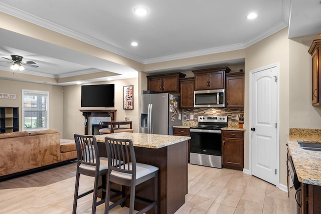 1561 Kestrel Dr, Clarksville, TN 37040 - kitchen with a kitchen bar, open floor plan, a center island, stainless steel appliances, and dark brown cabinetry