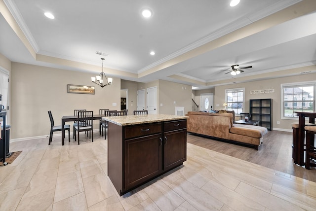 1561 Kestrel Dr, Clarksville, TN 37040 - kitchen featuring a tray ceiling, dark brown cabinetry, visible vents, and a center island