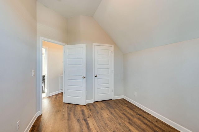 bonus room with visible vents, baseboards, dark wood-style floors, and vaulted ceiling