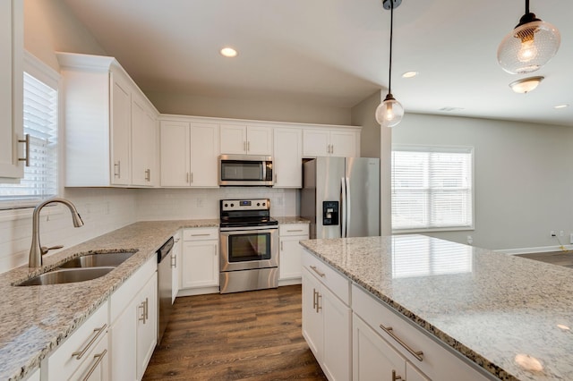 kitchen featuring appliances with stainless steel finishes, white cabinetry, dark wood-type flooring, and a sink