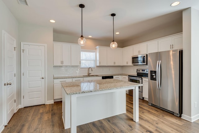 kitchen with a sink, visible vents, appliances with stainless steel finishes, and dark wood finished floors