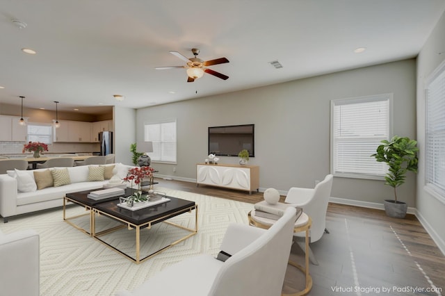 living room featuring visible vents, wood finished floors, a healthy amount of sunlight, and ceiling fan