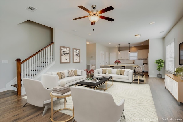 living area with visible vents, ceiling fan, stairs, recessed lighting, and wood finished floors