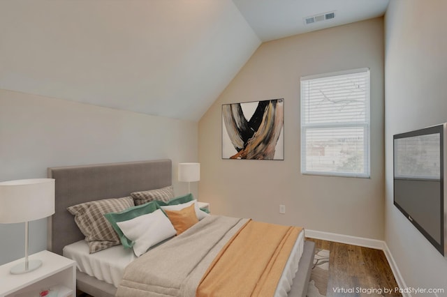 bedroom featuring lofted ceiling, wood finished floors, visible vents, and baseboards