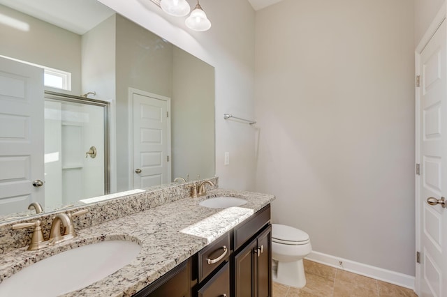 bathroom with a shower stall, toilet, baseboards, and a sink