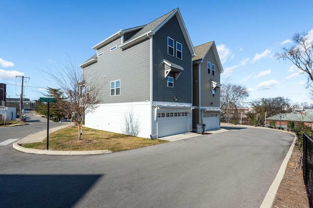 view of side of home with aphalt driveway and a garage