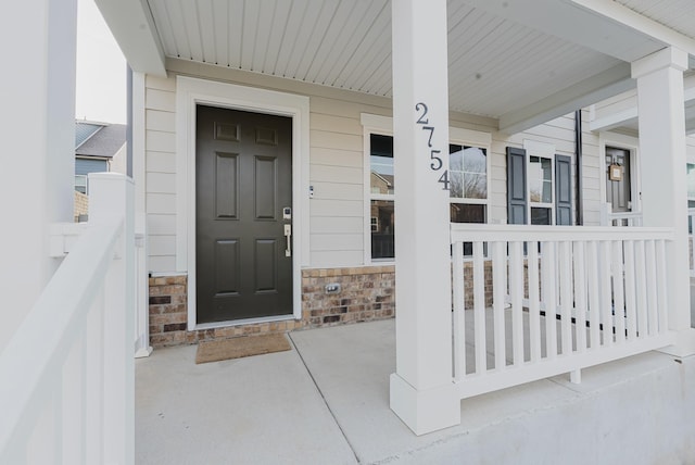 entrance to property with stone siding and covered porch
