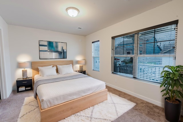 carpeted bedroom with visible vents and baseboards