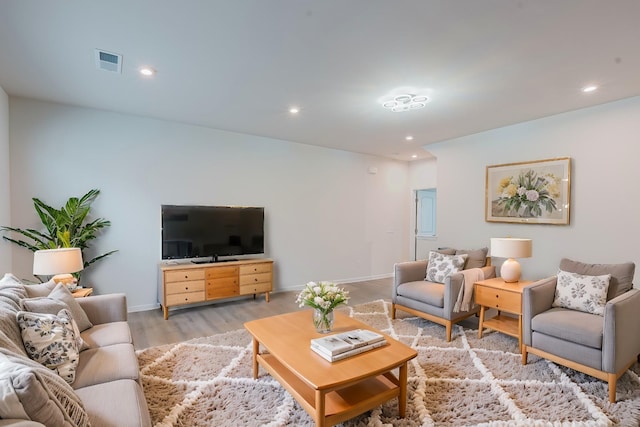 living area with visible vents, recessed lighting, light wood-type flooring, and baseboards