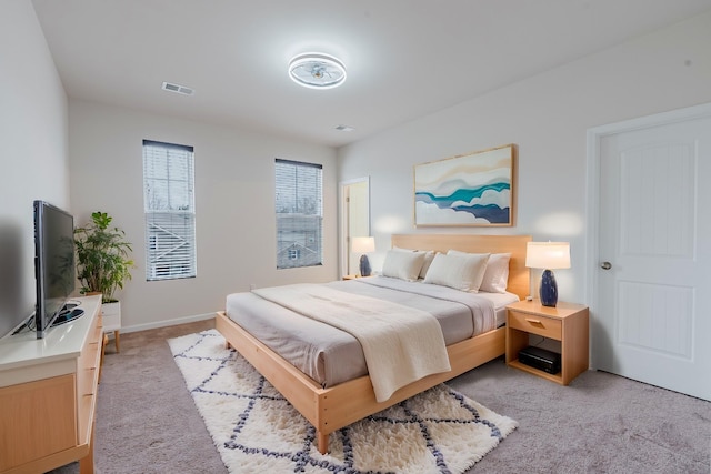 bedroom with visible vents and light carpet