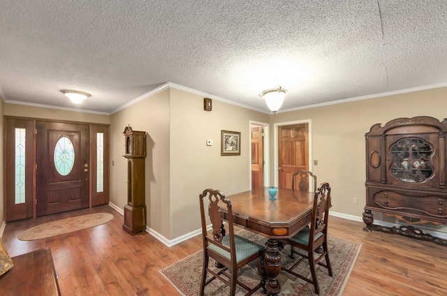 dining area with crown molding, baseboards, and light wood finished floors
