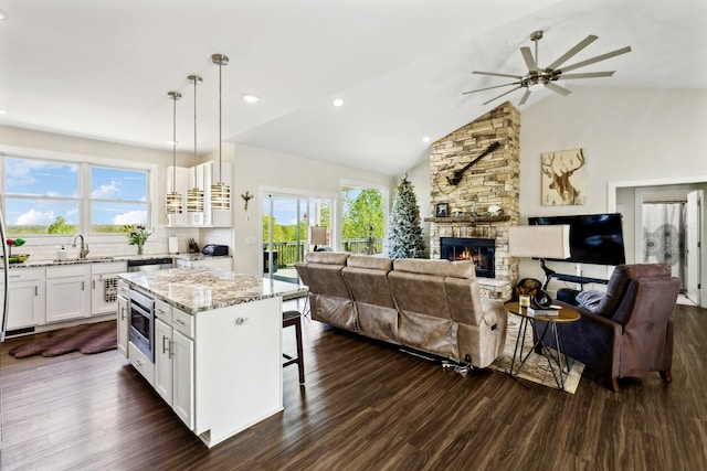 kitchen with open floor plan, dark wood-style floors, a breakfast bar, and ceiling fan