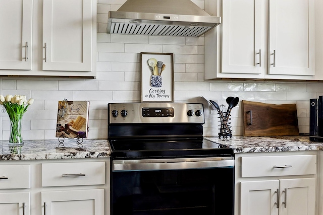 kitchen featuring stainless steel electric range oven, range hood, backsplash, and white cabinets