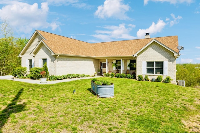ranch-style house featuring roof with shingles, a front yard, and brick siding
