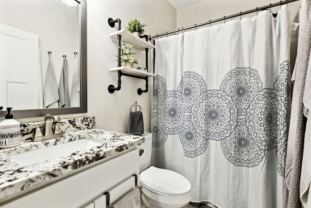 bathroom featuring toilet, a shower with shower curtain, and vanity