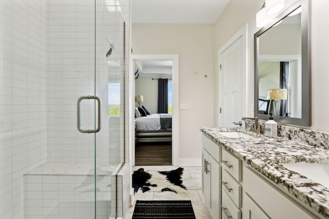 bathroom with a shower stall, ensuite bath, a sink, double vanity, and baseboards