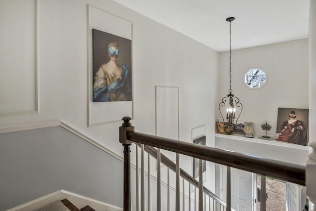 stairs featuring a chandelier and baseboards