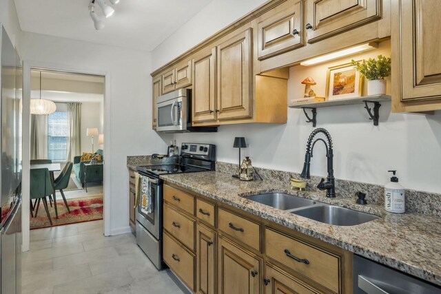 kitchen featuring light stone counters, appliances with stainless steel finishes, open shelves, and a sink