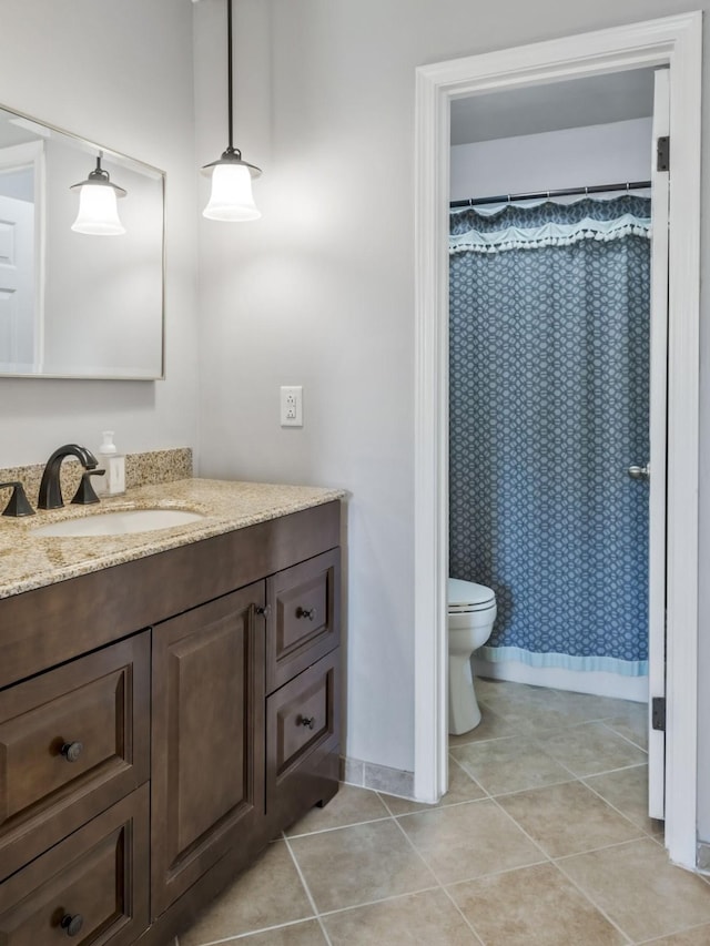 bathroom featuring tile patterned flooring, toilet, vanity, and baseboards