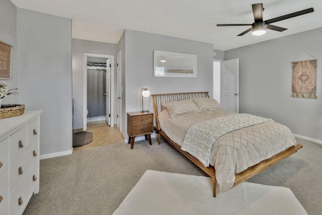 bedroom with light colored carpet, a ceiling fan, and baseboards