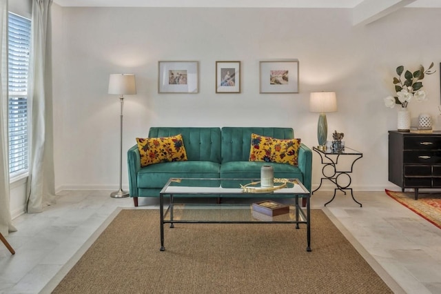 living room featuring beam ceiling and baseboards