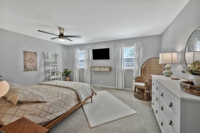 bedroom featuring a ceiling fan, light colored carpet, and baseboards
