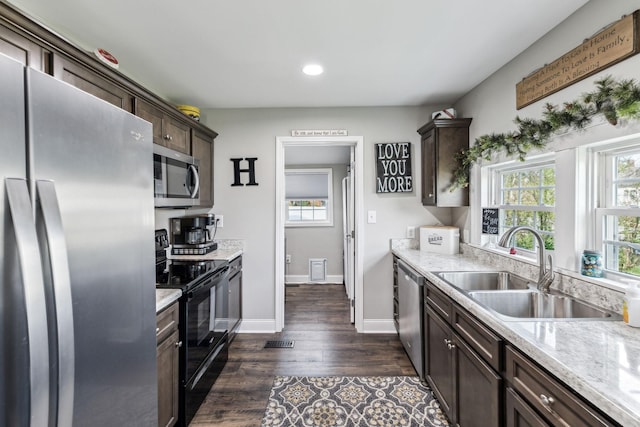 kitchen featuring dark wood-type flooring, dark brown cabinetry, a sink, and stainless steel appliances