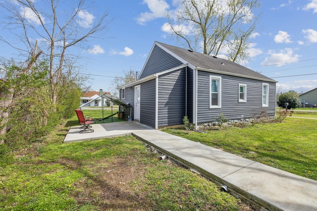 view of property exterior with a lawn and a patio area
