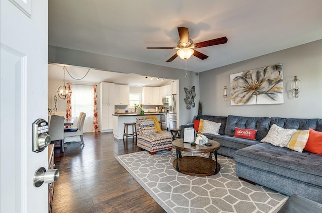 living area featuring dark wood-type flooring and ceiling fan