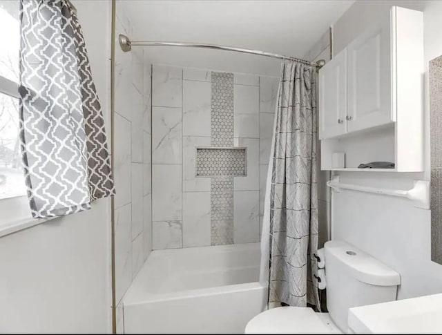 full bathroom featuring toilet and shower / bath combination with curtain