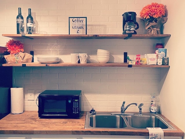 room details with a sink, open shelves, and black microwave