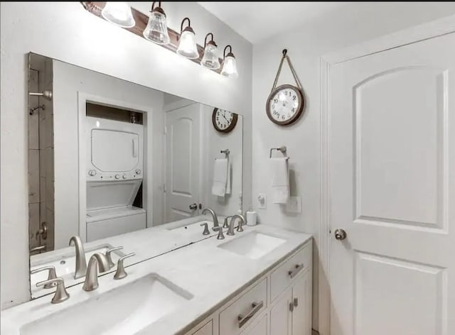 bathroom featuring a sink, stacked washer / drying machine, and double vanity