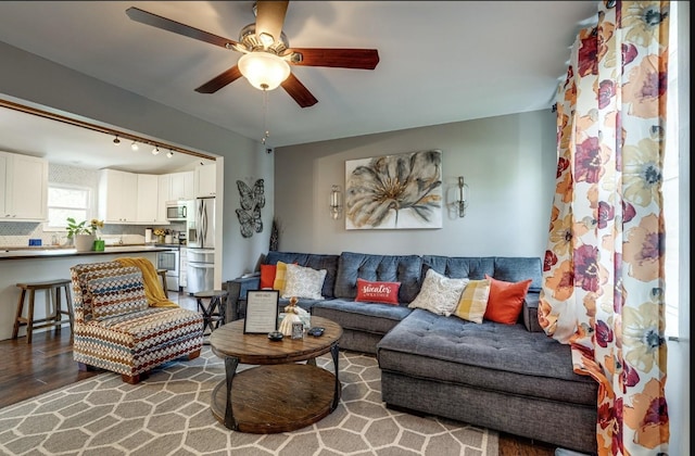 living area with wood finished floors and a ceiling fan