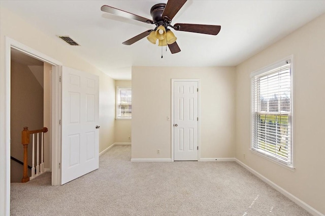 unfurnished bedroom featuring visible vents, baseboards, carpet, and a ceiling fan