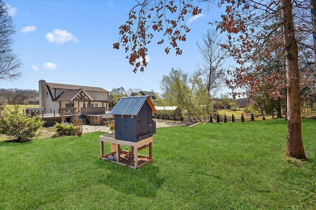 view of yard with an outdoor structure, a deck, and exterior structure