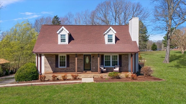 cape cod house with brick siding, covered porch, a chimney, and a front lawn