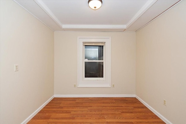 spare room with baseboards and wood finished floors