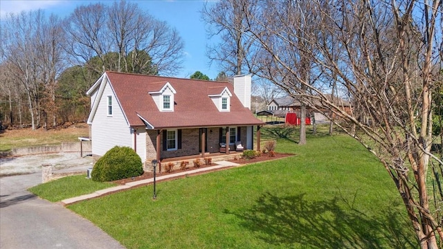 cape cod-style house featuring a front yard, driveway, a porch, a shingled roof, and a chimney
