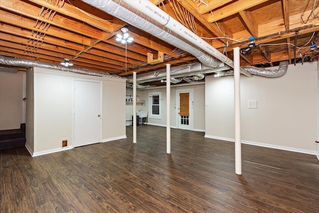 finished below grade area with baseboards and wood finished floors