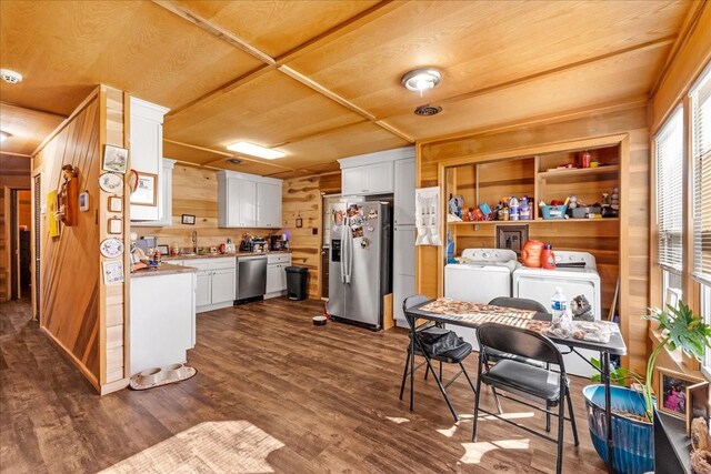 112 Shasteen St, Estill Springs, TN 37330 - kitchen featuring wood walls, stainless steel appliances, dark wood-type flooring, white cabinetry, and washing machine and dryer