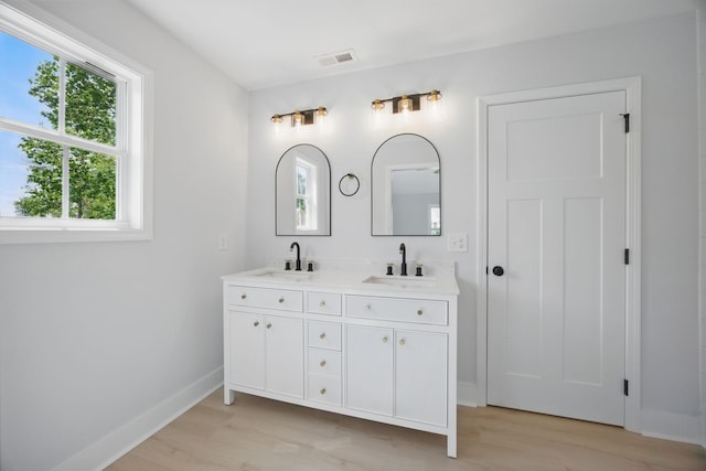 bathroom featuring visible vents, a sink, and wood finished floors