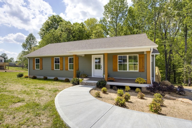 ranch-style house with a shingled roof, a front lawn, and covered porch