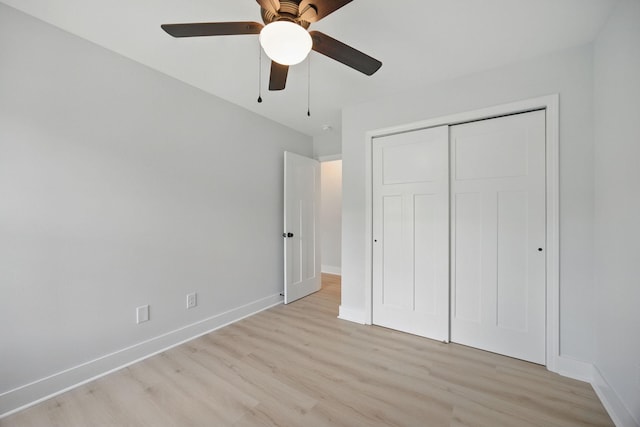 unfurnished bedroom with a closet, baseboards, a ceiling fan, and light wood-type flooring