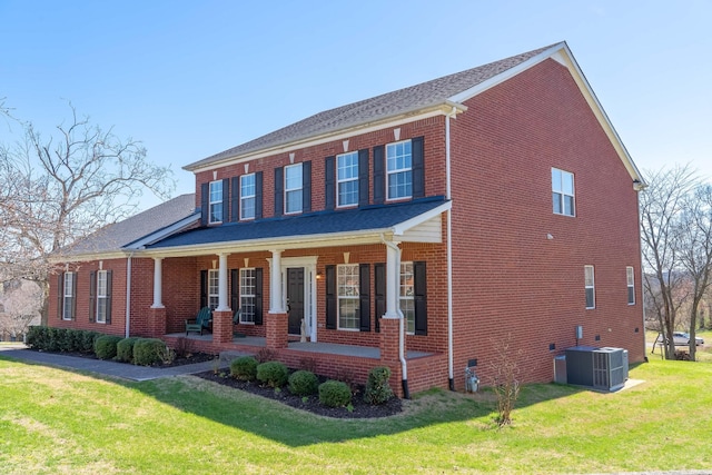 view of front of home with a front lawn, a porch, cooling unit, and brick siding