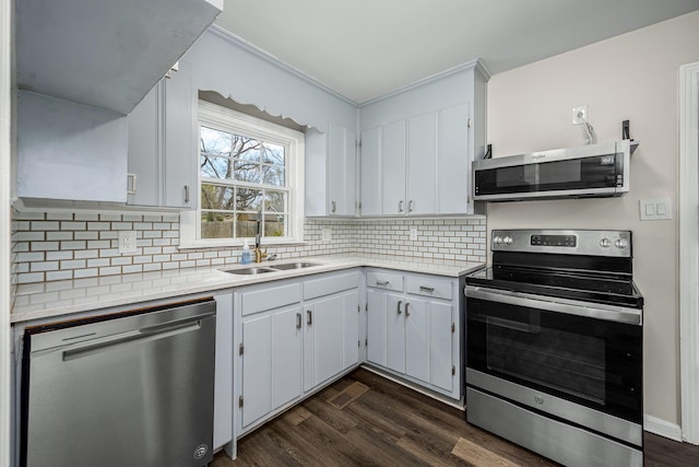 kitchen featuring a sink, light countertops, decorative backsplash, and stainless steel appliances