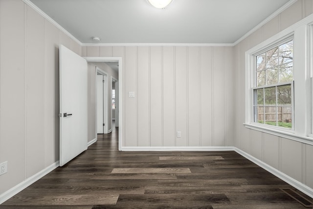 unfurnished room with a decorative wall, visible vents, crown molding, and dark wood-type flooring