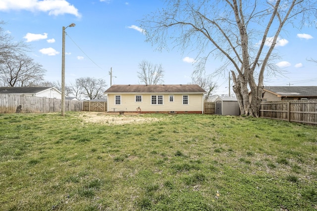 rear view of house with an outbuilding, a shed, a yard, a fenced backyard, and crawl space
